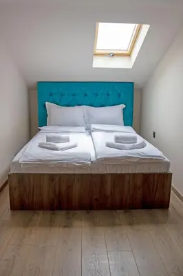 a bedroom with a large bed with a blue headboard at ELEVENROOMS in Belgrade