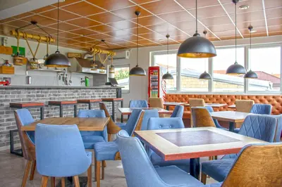 a dining room with blue chairs and tables in a restaurant at ELEVENROOMS in Belgrade