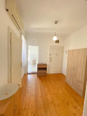 an empty living room with a wooden floor and a door at MAXIMUS VRACAR in Belgrade
