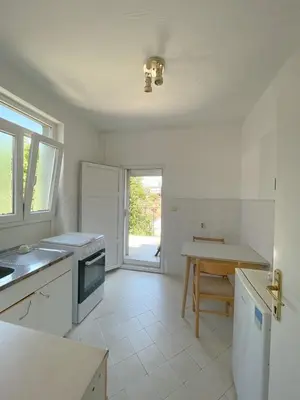 a white kitchen with a table and a counter top at MAXIMUS VRACAR in Belgrade