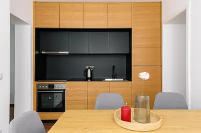 a kitchen with a wooden table with chairs and a dining room at Tim 3 in Belgrade