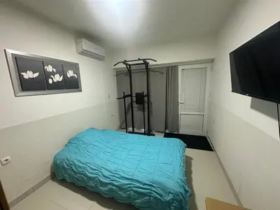 a bedroom with a bed with a blue blanket at Namesten apartman na dan in Voždovac