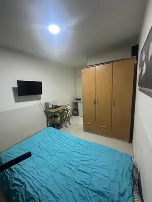 a bedroom with a blue bed and a desk at Namesten apartman na dan in Voždovac