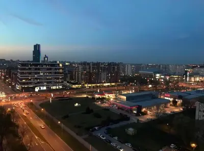 a city at night with a parking lot and buildings at Viewpoint in Belgrade