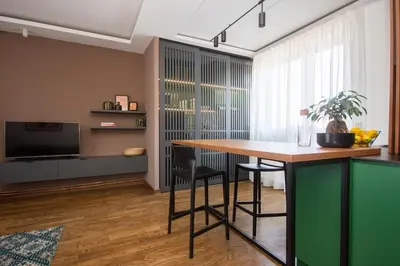 a living room with a table and a television at Artisan's Dwelling in Belgrade