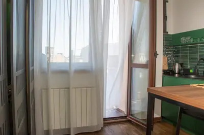 a kitchen with a window with white curtains at Artisan's Dwelling in Belgrade