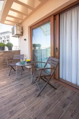 a patio with a glass table and chairs on a balcony at Artisan's Dwelling in Belgrade