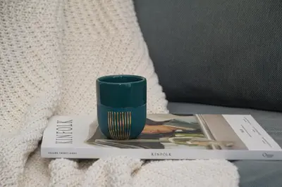 a green cup sitting on top of a book at Artisan's Dwelling in Belgrade