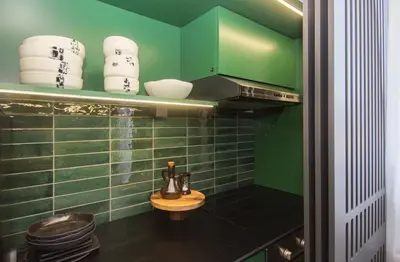 a green tiled bathroom with a sink and a toilet at Artisan's Dwelling in Belgrade