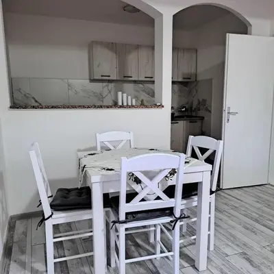 a kitchen with a white table and two chairs at Apartman Giovanni 2 in Arandjelovac
