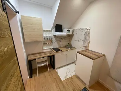 a small kitchen with a table and a refrigerator at Sofie - free parking place in the garage in Belgrade