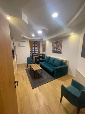 a living room with a green couch and chairs at Sofie - free parking place in the garage in Belgrade