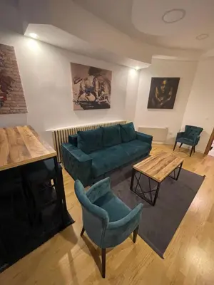 a living room with a green couch and a table at Sofie - free parking place in the garage in Belgrade