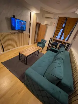 a living room with a green couch and a table at Sofie - free parking place in the garage in Belgrade
