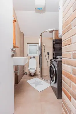 a bathroom with a washing machine and a sink at Apartman Kalvarija in Belgrade