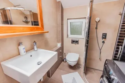 a bathroom with a sink and a toilet and a shower at Apartman Kalvarija in Belgrade