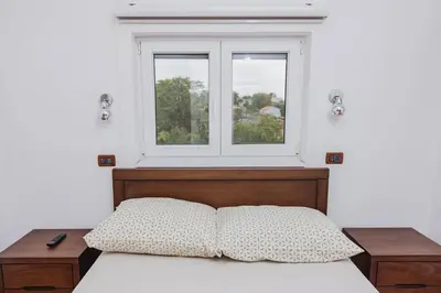 a bedroom with a bed and a window at Apartman Kalvarija in Belgrade