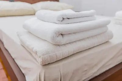 a stack of towels sitting on top of a bed at Apartman Kalvarija in Belgrade