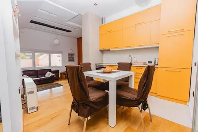 a kitchen and living room with a table and chairs at Apartman Kalvarija in Belgrade