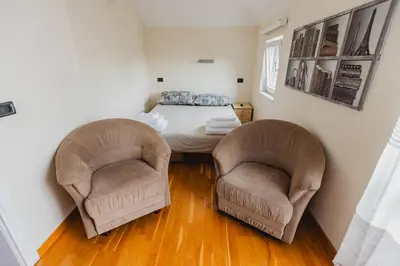 two chairs in a small room with a bed at Apartman Kalvarija in Belgrade