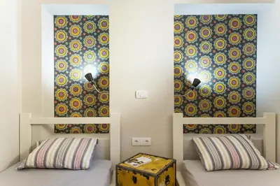 a room with two beds and a wall with a curtain at Hostel Bongo in Belgrade