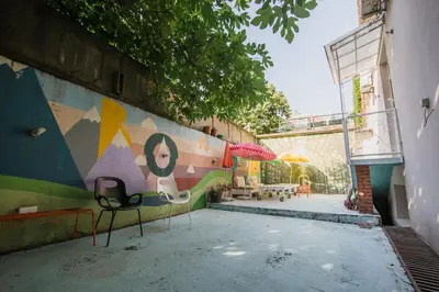 a wall with two chairs and a wall with a mural at Hostel Bongo in Belgrade