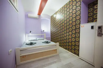 a bedroom with a bed in a room with purple walls at Hostel Bongo in Belgrade