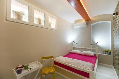 a small bedroom with a bed and a desk at Hostel Bongo in Belgrade