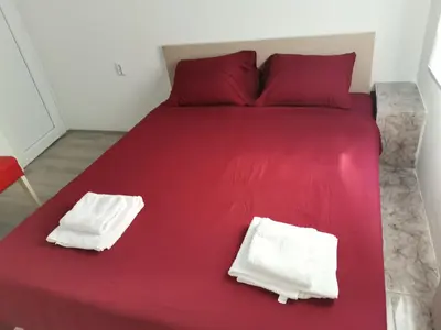 a red bed with two white pillows on it at ViP ROOMS PRENOCISTE 026 in Smederevo