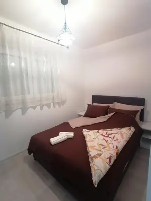 a bedroom with a large bed with two towels on it at Apartmani Glorija in Arandjelovac