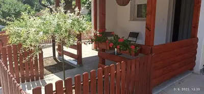 a house with a wooden fence and some plants at Apartmani Glorija in Arandjelovac