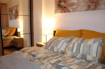 a bedroom with a bed and a bedroom with a mirror at Apartman Mila 21 in Zvezdara