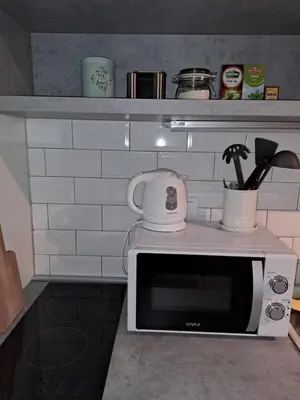 a microwave oven with a tea kettle on top of it at AVALA, New Belgrade in Fontana