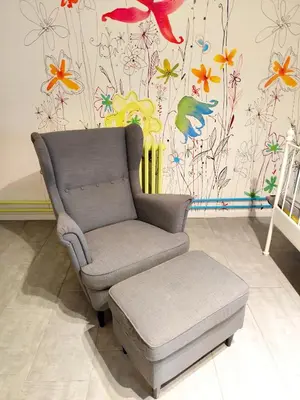 a chair and stool in a room with a flower wallpaper at AVALA, New Belgrade in Fontana