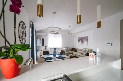 a kitchen and living room with a table and a couch at Afrodita apartman in Surčin