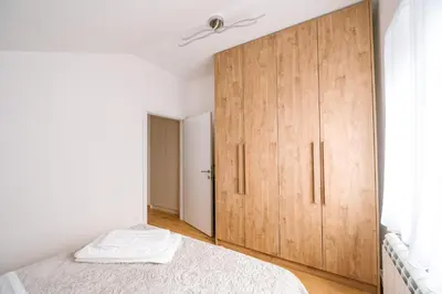 a bedroom with a large wooden cabinet and a bed at Afrodita apartman in Surčin