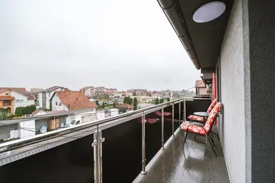 a balcony with chairs and a view of the water at Afrodita apartman in Surčin