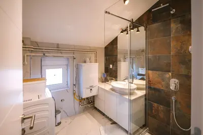 a bathroom with a sink and a toilet and a shower at Afrodita apartman in Surčin