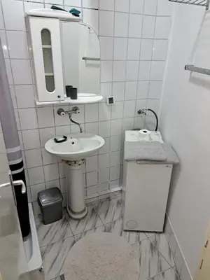 a white bathroom with a sink and a mirror at danguba 2 in Nova Pazova