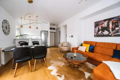 a living room with a couch and a table at Mikonos apartman in Surčin