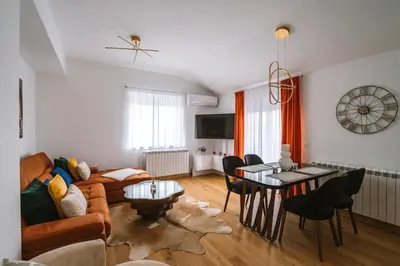 a living room with a couch and a table at Mikonos apartman in Surčin
