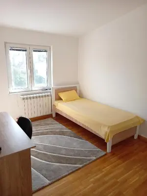 a bedroom with a bed and a rug and two windows at Itaka - Belgrade City Center in Belgrade