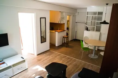 a living room with a table and a kitchen at Dukes Apartment in Belgrade