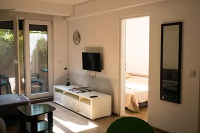 a small living room with a bed and a television at Dukes Apartment in Belgrade