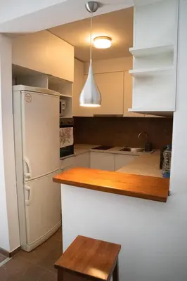 a kitchen with white cabinets and a white refrigerator at Dukes Apartment in Belgrade