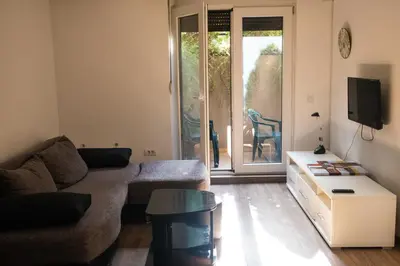 a living room with a couch and a tv at Dukes Apartment in Belgrade