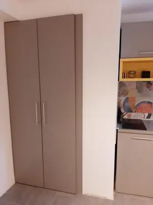 a white cabinet in a kitchen next to a refrigerator at ADA, New Belgrade in Tošin Bunar