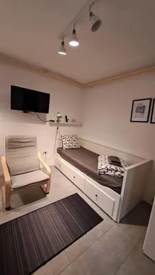 a bedroom with a bed and a chair and a tv at ADA, New Belgrade in Tošin Bunar