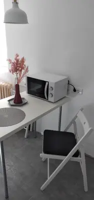 a white desk with a microwave and a chair at ADA, New Belgrade in Tošin Bunar