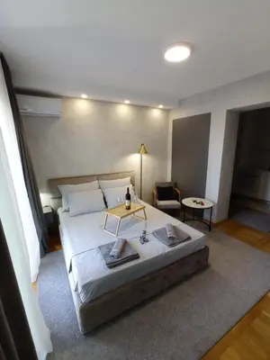 a bedroom with a large bed and a table at KaLuMa in Belgrade